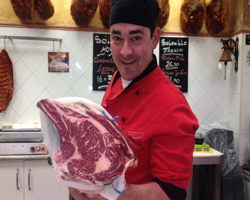 A butcher with a meat sample from Pepe Chuletón.