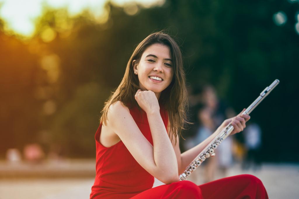 Portrait of Cristina Santirso dressed for a concert and with her flute in her hand.