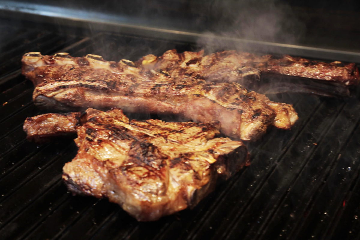 Two large chops cooking on the grill.