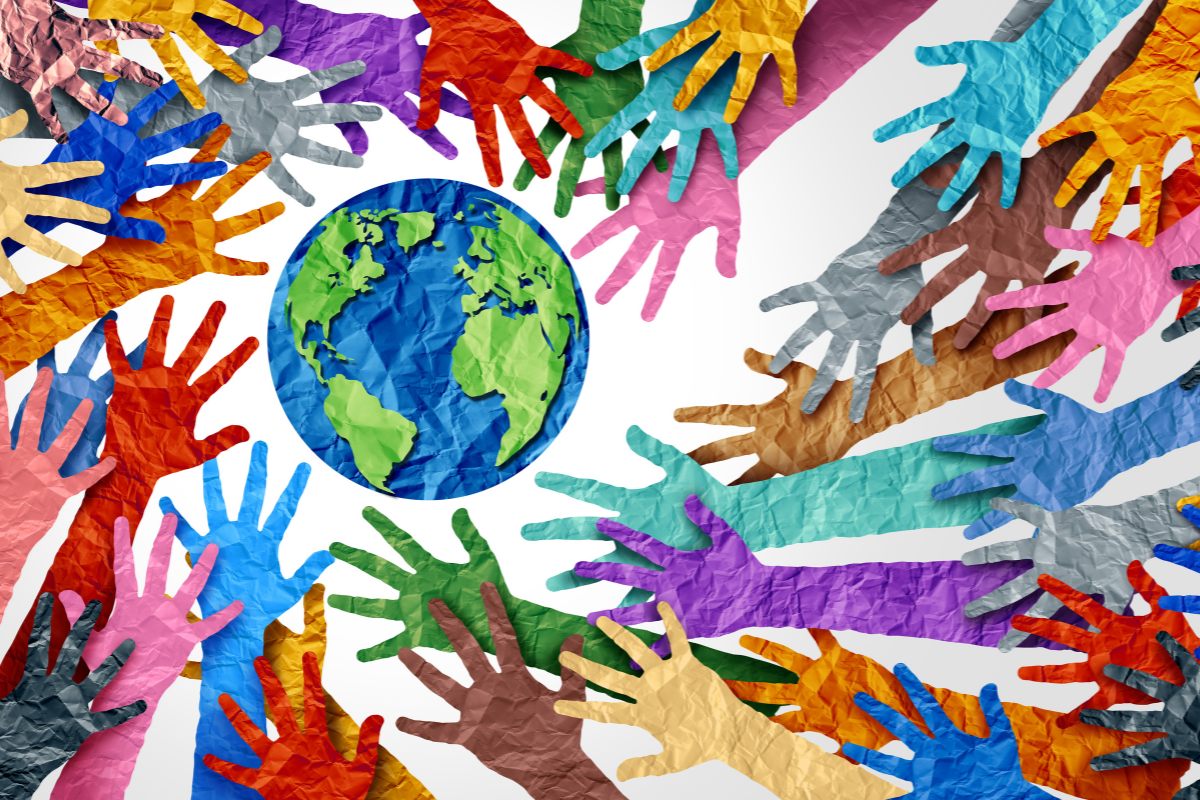 Colorful hands surrounding an image of the Earth representing World Art Day.