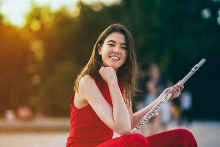 Portrait of Cristina Santirso dressed for a concert and with her flute in her hand.