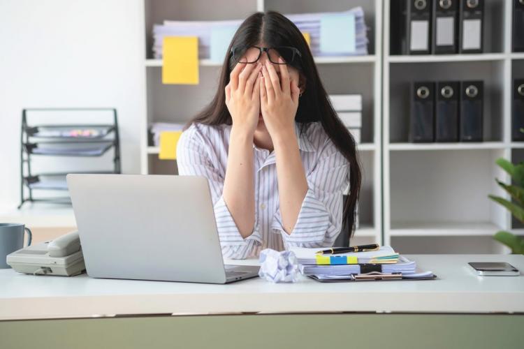 Concept burnout syndrome with a business woman feeling uncomfortable working; which is caused by stress, accumulated from unsuccessful work and not enough rest.