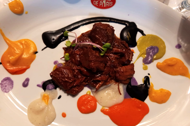Un plato de estofado de ternera con pinturas del chef, del chef Roberto Capone.