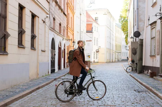 A young man exploring a city in a bike.