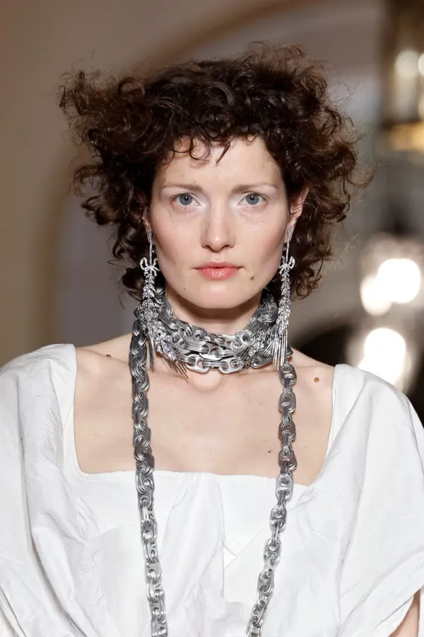 Un momento del desfile de trajes de novia centrándose en los complementos como collar y pendientes. Crédito BBFWeek25, Vivienne Westwood.