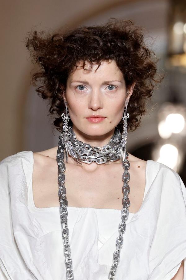 A moment from the bridal gown parade, focusing on accessories such as necklaces and earrings. Credits BBFWeek25, Vivienne Westwood.